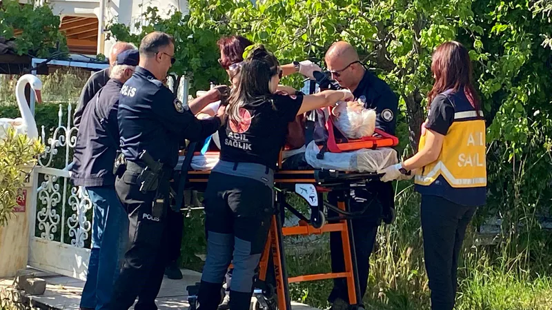 Ayvalık Sahilkent Mahallesi'nde 80 yaşlarındaki Nevin Gençer, evinin perdelerini takarken