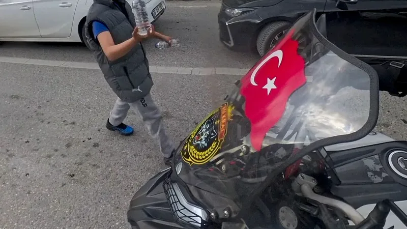 Eskişehir'de trafik ışığının altında su satan bir çocuk, camında Türk